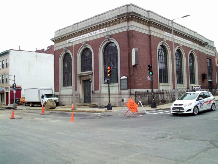 Alternative text: A photograph shows a local church at the corner of an intersection.