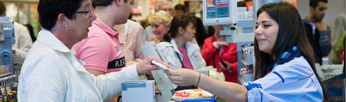 Female cashier handling a receipt.