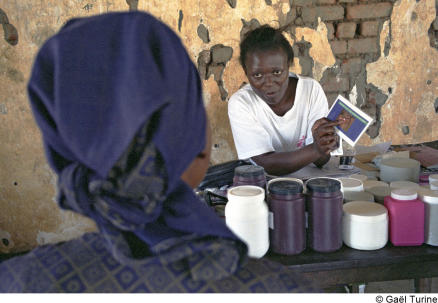 A health worker explains to a patient how to use a miconazole gum patch