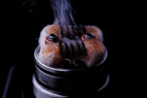 Photograph of an e-cigarette showing the exposed metal coil and saturated wick.