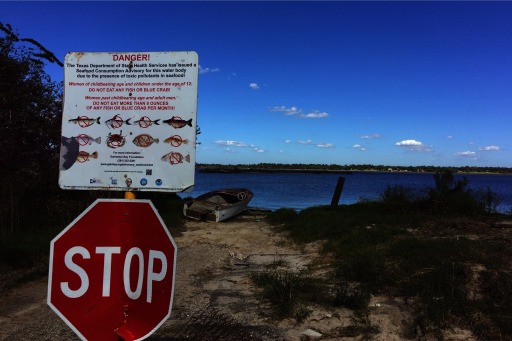 Photograph of a fishing spot on the San Jacinto River with a sign warning not to eat the fish