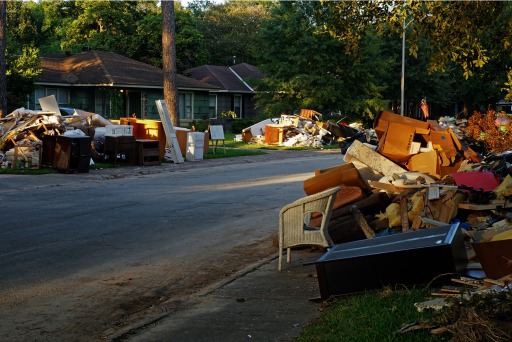 Photograph of a street in Houston with debris piled high on the curb