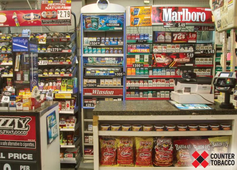 Photograph of tobacco products and advertising in a US convenience store. The advertisements are large and brightly colored and have no warning about the health effects of the products.