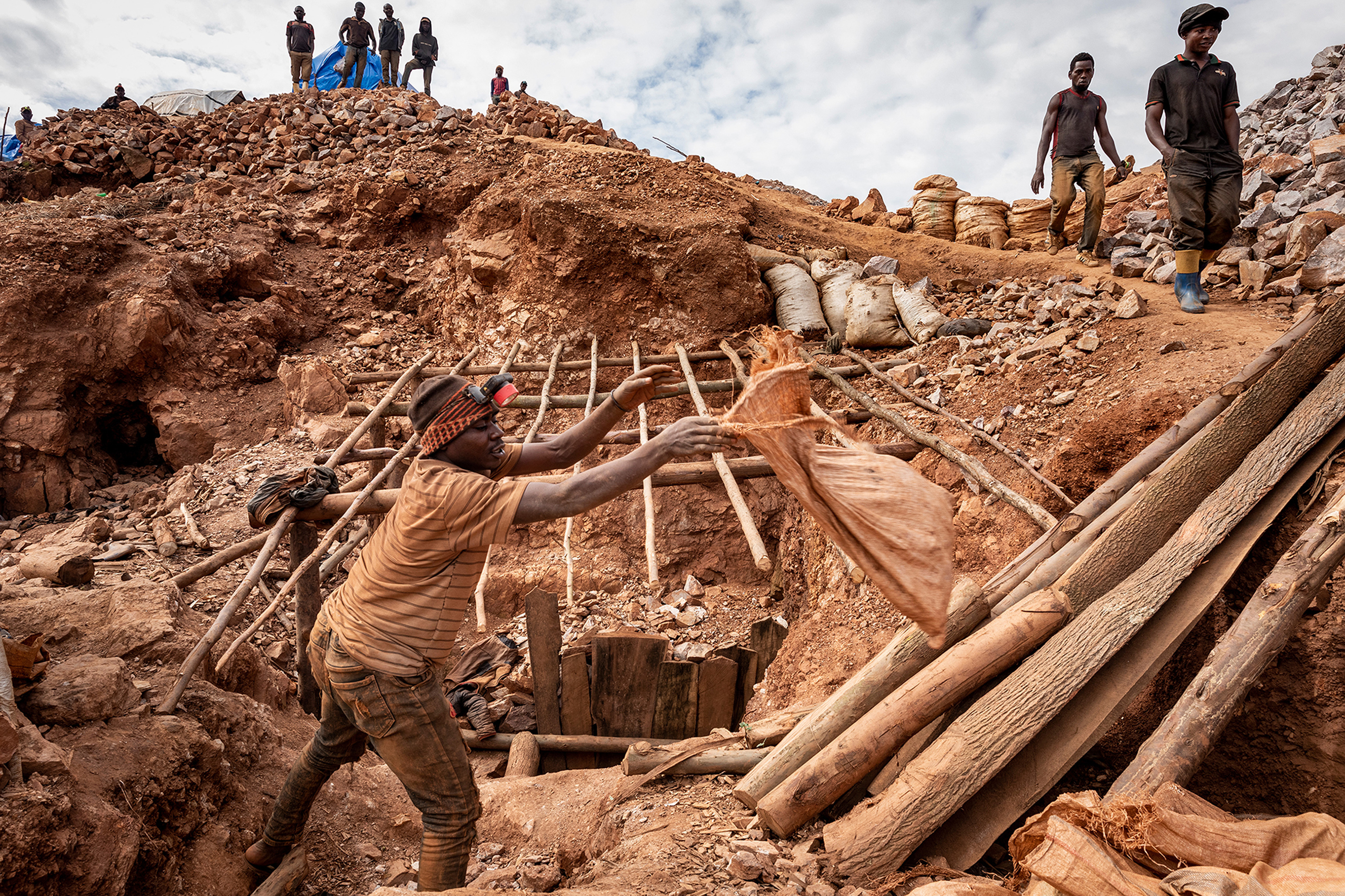 A man tossing a bag of dirt at an informal gold mine in the Democratic Republic of Congo.