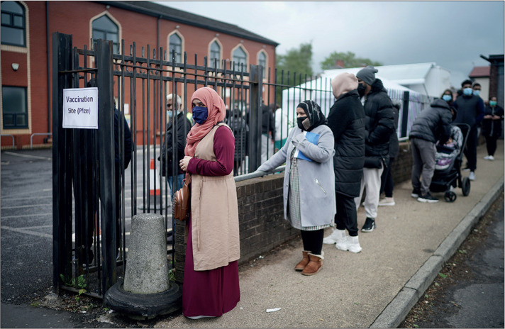 BLACKBURN, ENGLAND - MAY 24: People queue for Covid-19 vaccinations at a mobile vaccination clinic set up at the Masjid E Sajedeen Mosque in Little Harwood on May 24, 2021 in Blackburn, England. Blackburn with Darwen is one of England's Covid-19 hotspots, with 166 new cases reported at the weekend, with most cases involving the virus variant first identified in India. (Photo by Christopher Furlong/Getty Images)