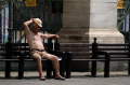 Photograph of a man who is uncomfortably hot sitting outdoors