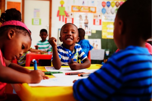 Photograph of young boys and girls working in a classroom.