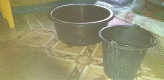 Figure 3: Two buckets, without lids placed next to Selina’s bed.