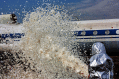 A firefighter spraying foam at a jet