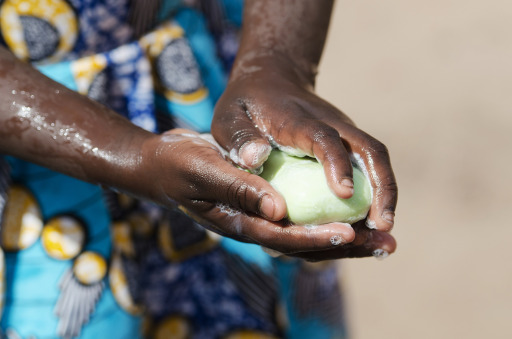 An African girl washing her hands at an outdoor tap