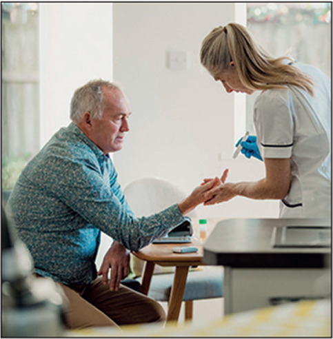 Senior diabetic man is having a check up at home from a district nurse. She is checking his blood glucose levels.