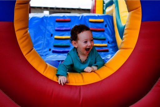 Photograph of a toddler happily playing in an indoor play setting