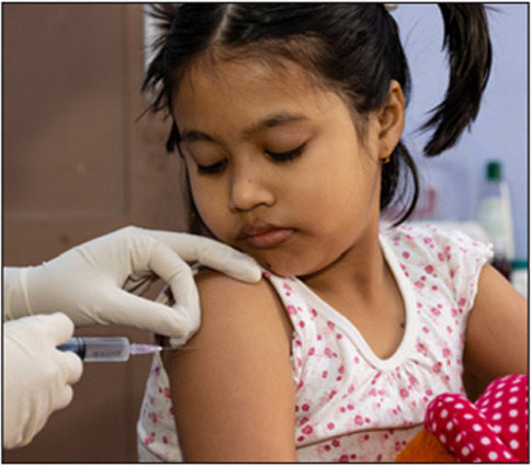 an Indian girl child looks at the needle during vaccination