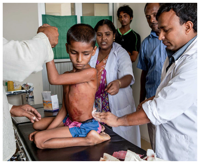 Trained health care professionals treat a boy aboard a hospital ship that provides responsive medical outreach to isolated communities along the Brahmaputra River, Bangladesh.