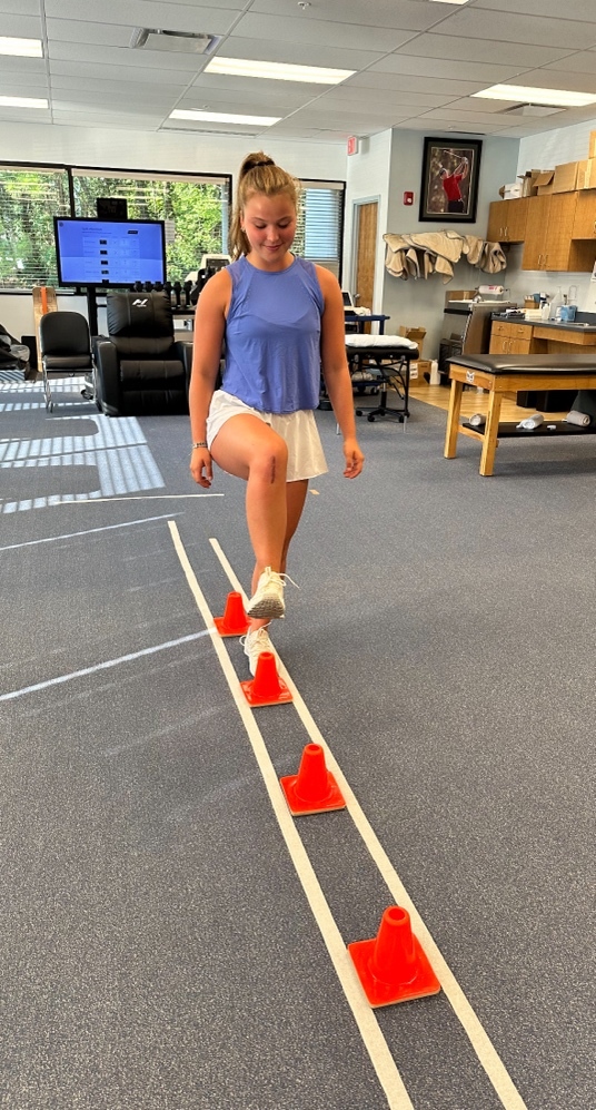 A person standing on a line of cones Description automatically generated