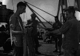 Archival photograph of Marines applying pesticides to clothing during World War II